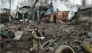  ?? YASUYOSHI CHIBA/GETTY-AFP ?? A police officer inspects damage from a rocket strike Thursday in Kramatorsk, Ukraine.