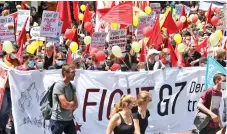  ?? ?? Demonstrat­ors hold signs and balloons during a protest, ahead of the G7 leaders summit in Munich, Germany