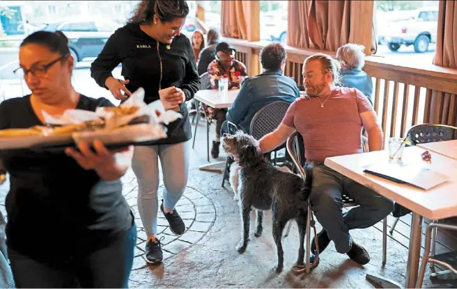  ?? ?? Hobbs and his dog Mattox getting ready to order at the Olive Lounge restaurant in Takoma Park, Maryland, the united States, recently.
— Photos: ap