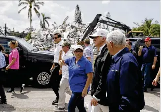  ?? EVAN VUCCI / AP ?? President Donald Trump and Vice President Mike Pence (right) walk a Hurricane Irma-damaged street in Naples, Fla., on Thursday. Trump later handed out sandwiches to residents.