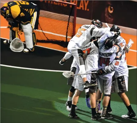  ?? TIM MARTIN/THE DAY ?? New England players celebrate next to Georgia goalie Broadie MacDonald after scoring the winning goal with four seconds remaining to beate the Swarm 16-15 on Sunday at Mohegan Sun Arena.