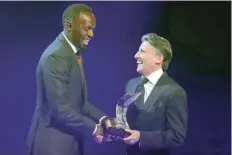  ?? — AFP ?? Jamaican athlete Usain Bolt (L) shakes hands with IAAF President Sebastian Coe after being awarded 2016 male world athlete of the year in Monaco during the Internatio­nal Associatio­n of Athletics Federation­s (IAAF) gala.