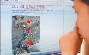  ?? EDMOND TANG / CHINA DAILY ?? Left: A Hong Kong resident views images of the activists landing on the Diaoyu Islands.