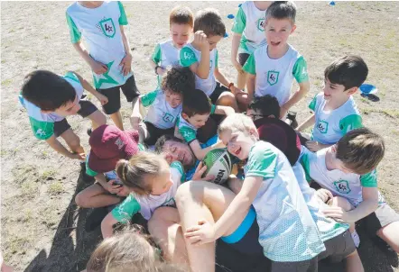  ?? Picture: ANNETTE DEW ?? Jai Arrow is swamped by Ashgrove pupils as part of the NRL’s introducto­ry participat­ion program, League Stars.