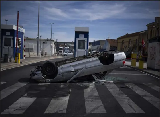  ?? DANIEL COLE — THE ASSOCIATED PRESS ?? A destroyed car placed by dock workers blocks the Marseille port entrance in Marseille, in southern France, on Friday.