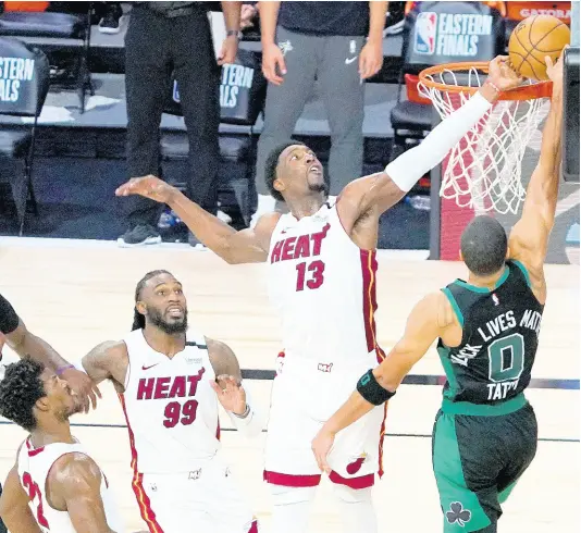  ?? AP ?? Miami Heat’s Jimmy Butler (bottom left) and Jae Crowder (second left) look on as Bam Adebayo (#13) blocks a shot attempt by Boston Celtics’ Jayson Tatum in the closing seconds of overtime of Game 1 of the NBA Eastern Conference Finals on Tuesday, September 15, in Lake Buena Vista, Florida. The Heat won 117-114.