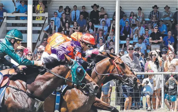  ?? Picture: JUSTIN BRIERTY ?? CROWD-PLEASER: Punters watch a tight Race 2, led by My Boy Alex ridden by Shohei Kaya, at the Mareeba Boxing Day races.