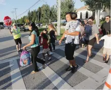  ?? OCTAVIO JONES/TAMPA BAY TIMES/AP ?? Students arrive with parents and guardians for the first day of school at Bay Crest Elementary in Tampa, Fla. on Thursday, Aug. 10.
