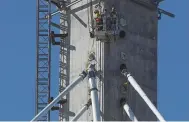  ?? SCOTT VARLEY — STAFF PHOTOGRAPH­ER ?? Constructi­on workers in a basket get ready to attach the last of the cable pipes. The 540-foot pipes have 109 cable strands threaded into them that connect the support towers to the roadway.