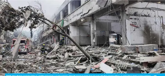  ??  ?? SHIYAN, China: Workers search for victims in a building damaged by a gas line explosion which left at least 12 people dead and nearly 140 others injured in Shiyan, in central China’s Hubei province yesterday. — AFP