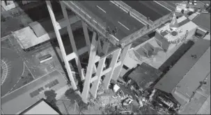  ?? The Associated Press ?? AERIAL VIEW: In this frame taken from a video released by the Vigili del Fuoco (Firefighte­rs), an aerial view of the collapsed Morandi highway bridge is shown Saturday in Genoa. Saturday was declared a national day of mourning in Italy and included a state funeral at the industrial port city’s fair grounds for those who plunged to their deaths as the 150-foot tall Morandi Bridge gave way Tuesday.