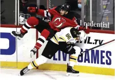  ?? Getty images ?? GETTING THEIR FEET UNDER THEM: New Jersey’s Michael McLeod collides with Kevan Miller in the second period.