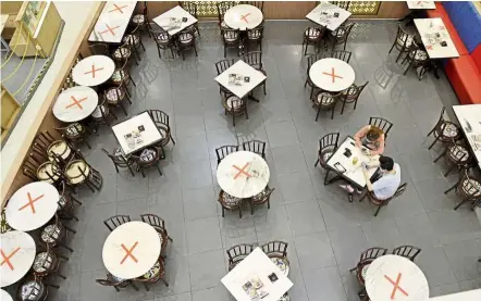  ??  ?? Dining with a distance: The social distancing markers set up at restaurant­s for dine-in customers at a mall in Penang.