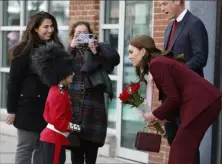  ?? Associated Press ?? Henry Dynov-Teixeira, 8, of Somerville, Mass., presents flowers to Britain's Prince William and Kate, Princess of Wales, as his parents Melissa, left, and Irene, look on following a visit Thursday to Greentown Labs in Somerville.