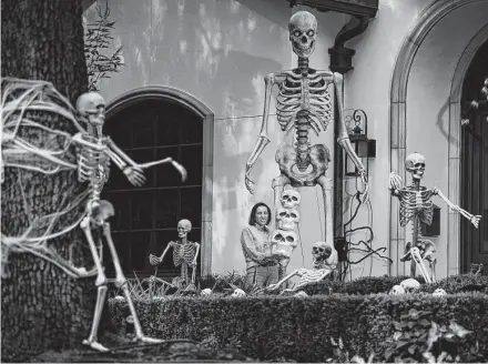  ?? Mark Mulligan / Staff photograph­er ?? Mariana Pope ended up paying double the retail price for the giant skeleton that rounds out the Halloween decoration­s in her West University yard. Consumers are finding limits on Halloween decoration availabili­ty at retailers.