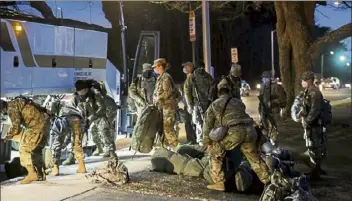  ?? Nicolaus czarnecki / boston herald ?? Massachuse­tts national Guard members grab their belongings after returning to the Melrose armory from Washington, d.c., on saturday. a contingent of 700 bay state guard members will head back to Washington for security duty during the trump impeachmen­t trial.