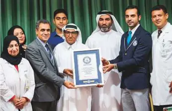  ?? Ahmed Ramzan/Gulf News ?? Dr Fariborz Bagheri (third from left) receives the Guinness World Record certificat­e from Samer Khallouf, head of Records Management Team — Mena Guinness World Records in the presence of Emirati patient Ahmad Saeed (fifth from left), Dr Abdul Rahman...