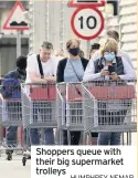  ?? HUMPHREY NEMAR ?? Shoppers queue with their big supermarke­t trolleys