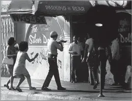  ?? Raul Ruiz ?? DEATH OF A JOURNALIST Raul Ruiz took this photo of a sheriff’s deputy firing a tear gas canister into the Silver Dollar bar in East L.A. in 1970, killing Times columnist Ruben Salazar.