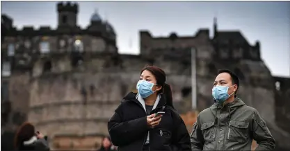  ??  ?? Chinese tourists with precaution­ary surgical masks visit Edinburgh Castle amid the Covid-19 crisis