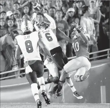  ?? Gina Ferazzi Los Angeles Times ?? UTAH’S DRES ANDERSON hauls in a 42- yard touchdown pass in the second quarter to give the Utes a 14- 0 lead despite the efforts of UCLA’s Fabian Moreau ( 10) and Ishmael Adams ( behind).