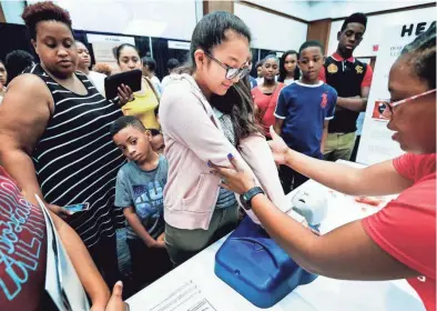  ??  ?? Leslie Avila, 13, middle, demonstrat­es the proper CPR technique during the C2 Institute Showcase (College, Career & Technology Education) at University Center on the University of Memphis campus. The C2 Institute introduced middle and high school...