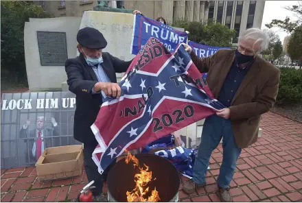  ?? PETE BANNAN — MEDIANEWS GROUP ?? Eugene Stilp, left, of Dauphin County burns a Confederat­e battle flag with the words “Re- elect President Donald Trump 2020” on it Wednesday at the Chester County Courthouse.