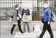  ??  ?? A lone protestor holds a placard as he demonstrat­es outside government buildings in Dublin, Ireland on Oct 9, whilst Irish Finance Minister PaschalDon­ohoe unveils his 2018 budget. (AFP)