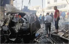  ??  ?? CARNAGE Locals pick through rubble and wreckage in Idlib