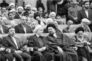  ?? — Reuters photo ?? Rouhani (second left) sits next to Hassan Khomeini, the grandson of the Islamic Republic’s founder Ayatollah Ruhollah Khomeini, during a ceremony commemorat­ing the death of Ruhollah Khomeini’s son, in Tehran.