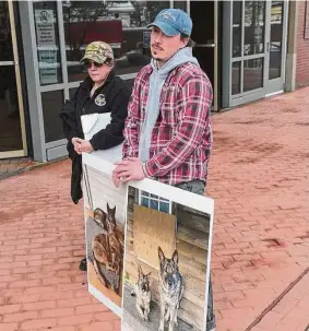  ?? ?? Shane Caviola with photos of his family’s dogs Cimo, right, and Lieben, left, on a poster outside state Superior Court in Danbury on Wednesday.