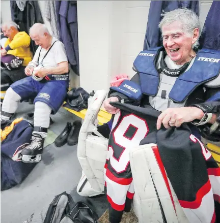  ?? JOHN MAHONEY ?? Goaltender Ron Daley, 80, laughs with teammates as he takes off his gear following an old-timers game at the Dorval Arena.