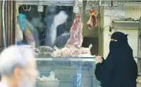  ?? (Faisal Al Nasser/Reuters) ?? A SAUDI WOMAN buys meat in Jedda’s Bab Makkah outdoor market on Tuesday.