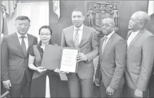  ??  ?? Prime Minister, Andrew Holness (centre); and President of China Harbour Engineerin­g Company Limited’s (CHEC) Americas Division, Dr Zhimin Hu (second from left), display the signed agreement for the $9.5billion Catherine Estates housing developmen­t in St Catherine, during a ceremony at Jamaica House yesterday. (Photo: JIS)