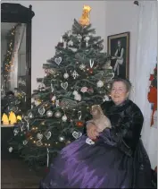  ??  ?? Docent Melinda Brown sits in the foyer of the Dr. Samuel Mudd House during its 15th annual Victorian Christmas event Saturday.