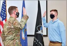  ?? SGT. JEREMY MCGUFFIN/ U.S. AIR FORCE ?? Col. John Schutte, 19th Airlift Wing commander, left, gives the Oath of Enlistment to Kendall Crowder during a ceremony at the Little Rock Air Force Base on March 11. Crowder is the first enlistee from Arkansas to be sworn into the Space Force.