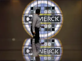  ?? (AP/Mel Evans) ?? A man looks back at the Merck logo on a stained glass panel at a Merck company building in Kenilworth, N.J. Merck’s covid-19 antiviral drug molnupirav­ir could generate as much as $7 billion in global sales through 2022, the drugmaker said.