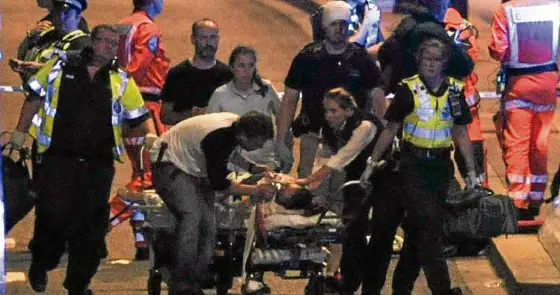  ?? —AFP ?? MEDICAL HELP Police and emergency workers attend to one of the victims of a terror attack on London Bridge in central London.