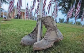  ?? NICK OZA/ARIZONA REPUBLIC ?? Volunteers returned to Tempe Beach Park Friday morning to erect flags to honor the victims of the Sept. 11, 2001, terror attacks at the 14th annual Tempe Healing Field.