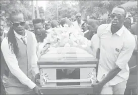  ??  ?? Jamaica’s Olympic champion Usain Bolt (R) carries the coffin of high jump star Germaine Mason, who died on April 20 in a motorbike crash on the outskirts of Kingston, to the cemetery in Grange Hill, Portland, Jamaica (REUTERS/Gilbert Bellamy)