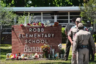  ?? JAE C. HONG/AP PHOTO ?? Flowers and candles are placed outside Robb Elementary School in Uvalde, Texas, on Wednesday to honor the victims killed in Tuesday’s shooting at the school.