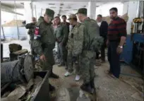  ?? THE ASSOCIATED PRESS ?? Russian military police officers check weapons left behind by members of the Army of Islam group in a factory produced weaponsin the town of Douma, the site of a suspected chemical weapons attack, near Damascus, Syria, Monday.