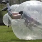  ??  ?? Star reporter Lauren Pelley falls head over heels for bubble ball at a fundraiser at Crawford Academy in North York.