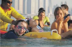  ?? Team Angel Wolf ?? Children can enjoy beach time during Fairmont The Palm’s weekly Beach Blast, above, with the help of floating wheelchair­s, right