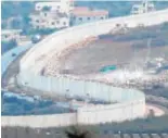  ??  ?? Arriba, miembros de Hizbolá en el túnel al ser descubiert­os. Sobre estas líneas, trabajos del Ejército israelí en Metula (imagen de Efe)