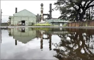  ?? The Maui News / MATTHEW THAYER photo ?? Shuttered Puunene Mill is reflected in a puddle left by Tropical Storm Olivia on Sept. 12. Sugar operators from Florida and Central America currently are removing parts from the old mill..