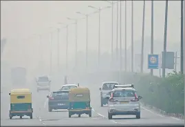  ?? ?? Commuters make their way along a road amid smoggy conditions in New Delhi on Sunday.