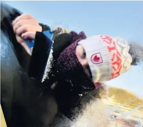  ?? PETER BOLTER ?? A resident of Longacres, Bridgend, scrapes ice off a car windscreen yesterday morning