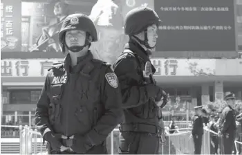  ?? AP PHOTO ?? ARMED policemen guard their positions in front of Kunming Railway Station in Kunming, in western China’s Yunnan province, Sunday. More than 10 assailants on Saturday slashed scores of people with knives at the train station, drawing police fire, in...