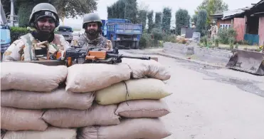  ?? — H. U. Naqash ?? Security force personnel stand guard behind a newly- built sandbag bunker in Srinagar